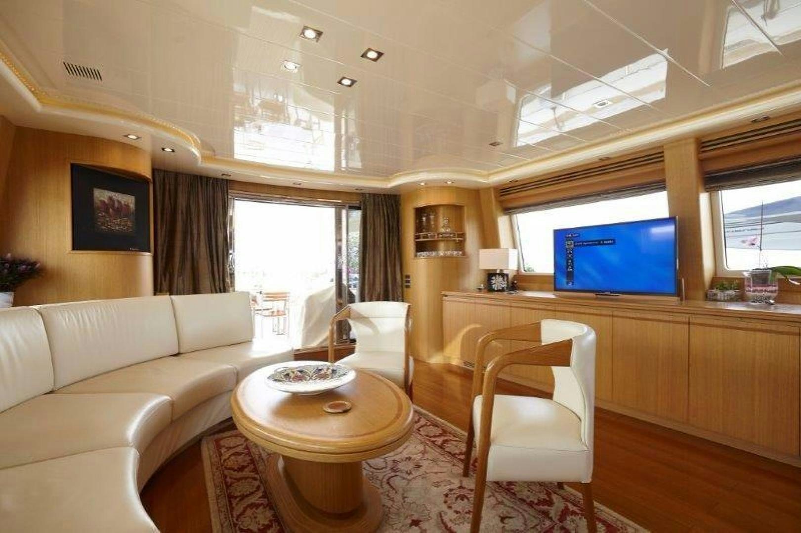 a living room with a tv and a table aboard YASSON Yacht for Sale