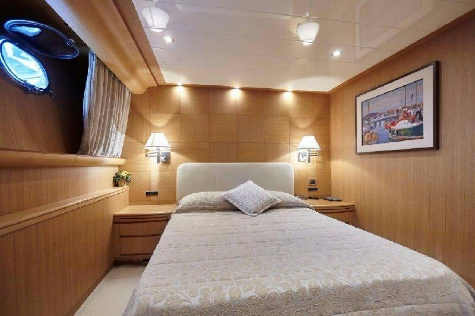 a bed with a white sheet and pillows in a room with a wood wall and a window with aboard YASSON Yacht for Sale