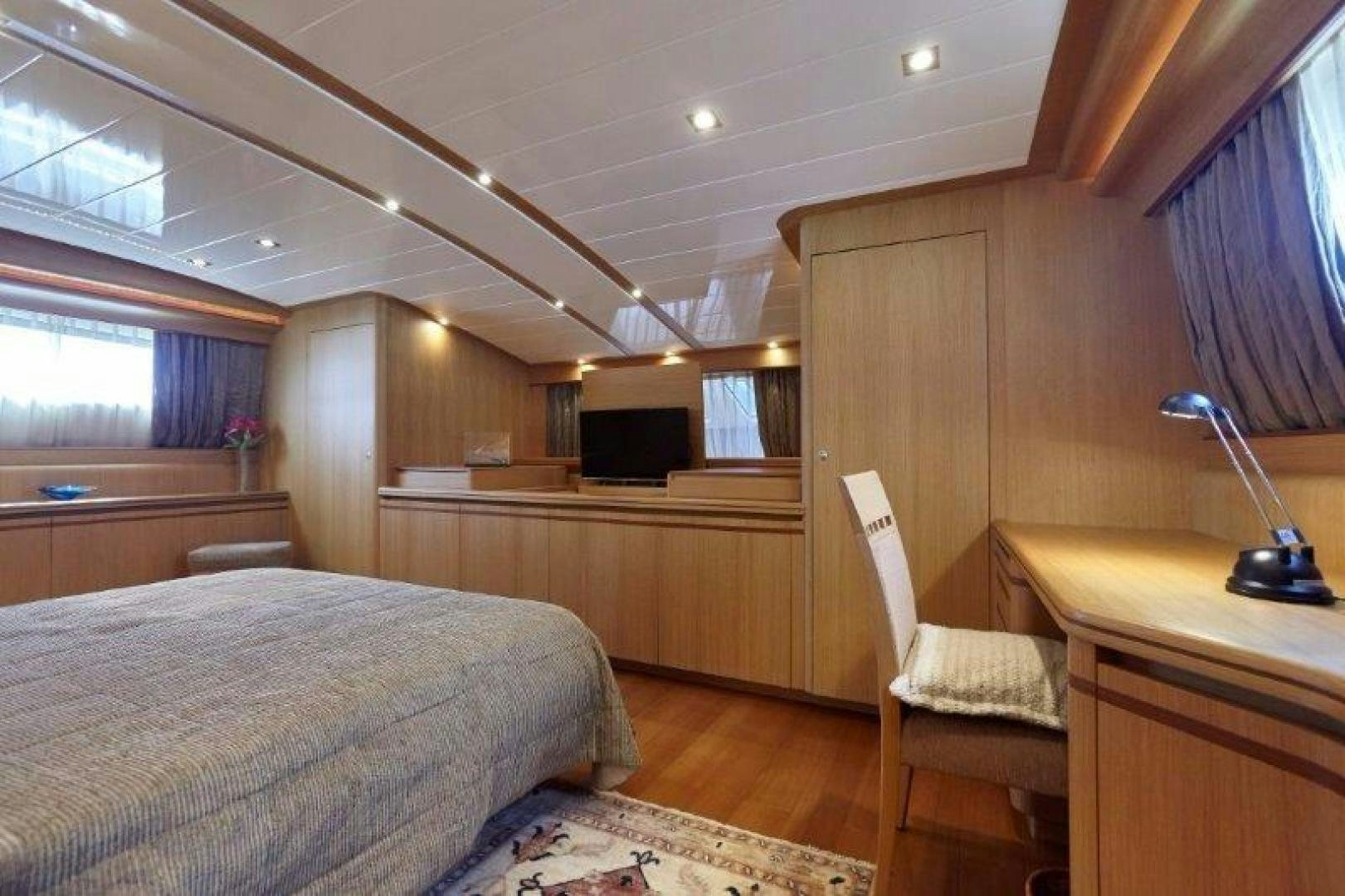 a bedroom with a bed and a desk aboard YASSON Yacht for Sale