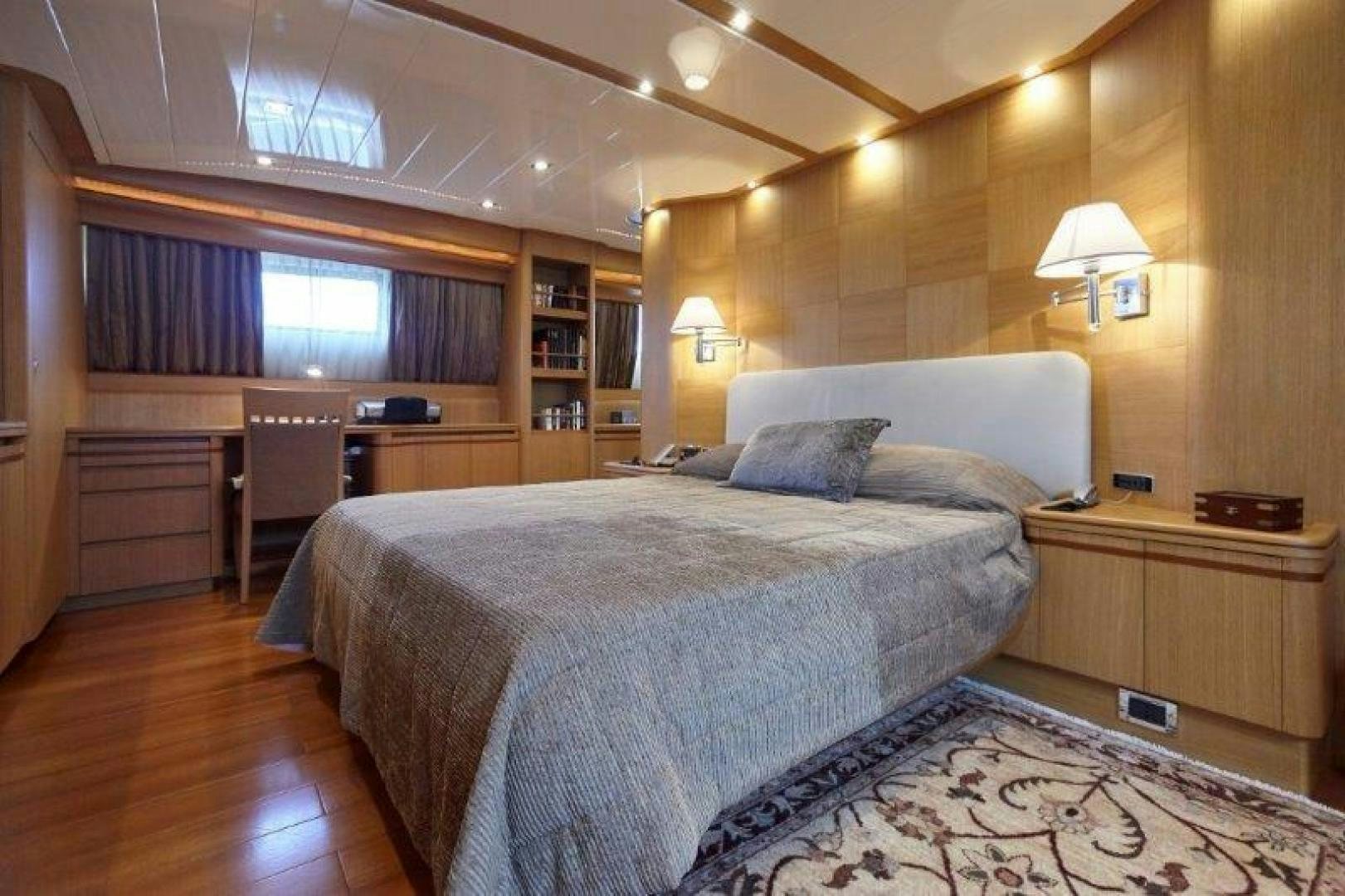 a bedroom with a bed and desk aboard YASSON Yacht for Sale