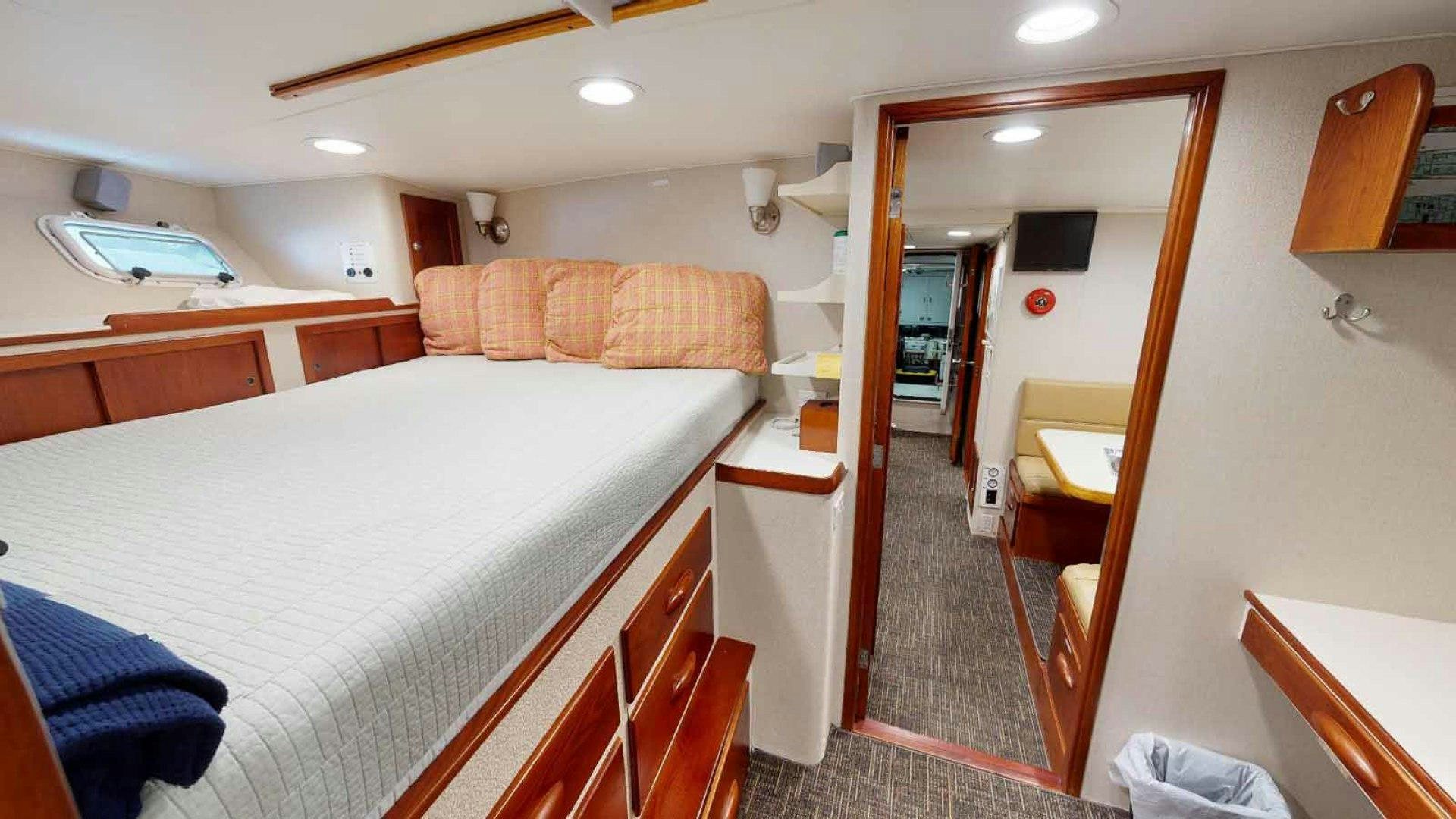 a bedroom with a bed and a mirror aboard LORELEI Yacht for Sale