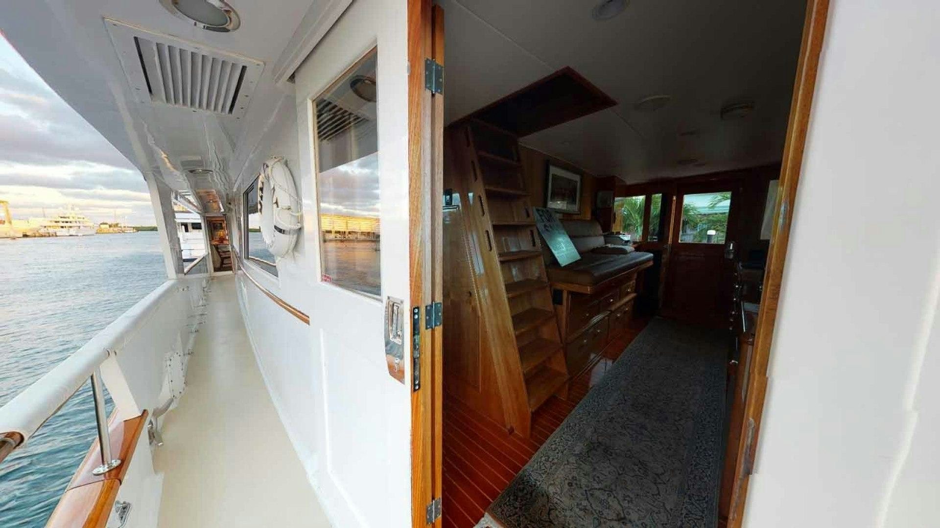 a room with a balcony and a table and a clock on the wall aboard LORELEI Yacht for Sale