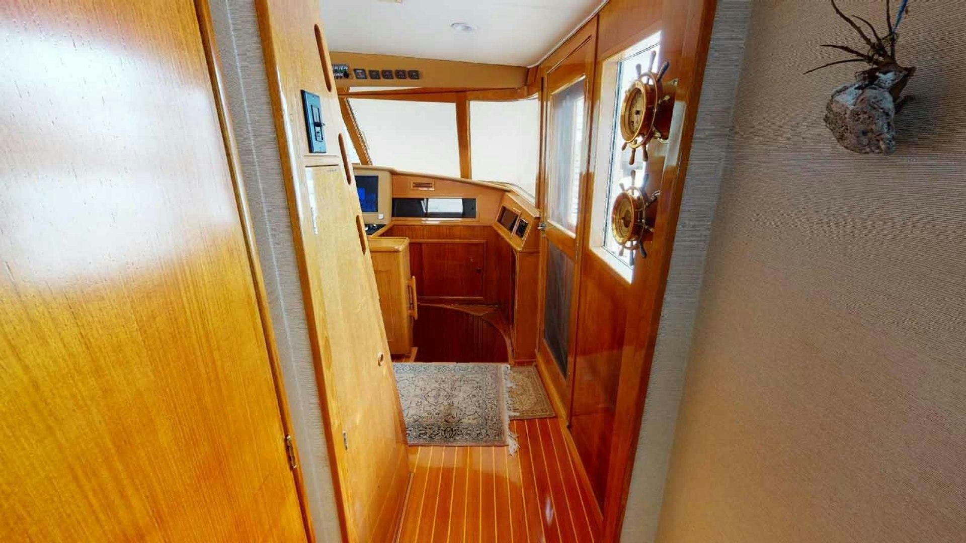 a hallway with a wood floor and a door with a plant on the side aboard LORELEI Yacht for Sale