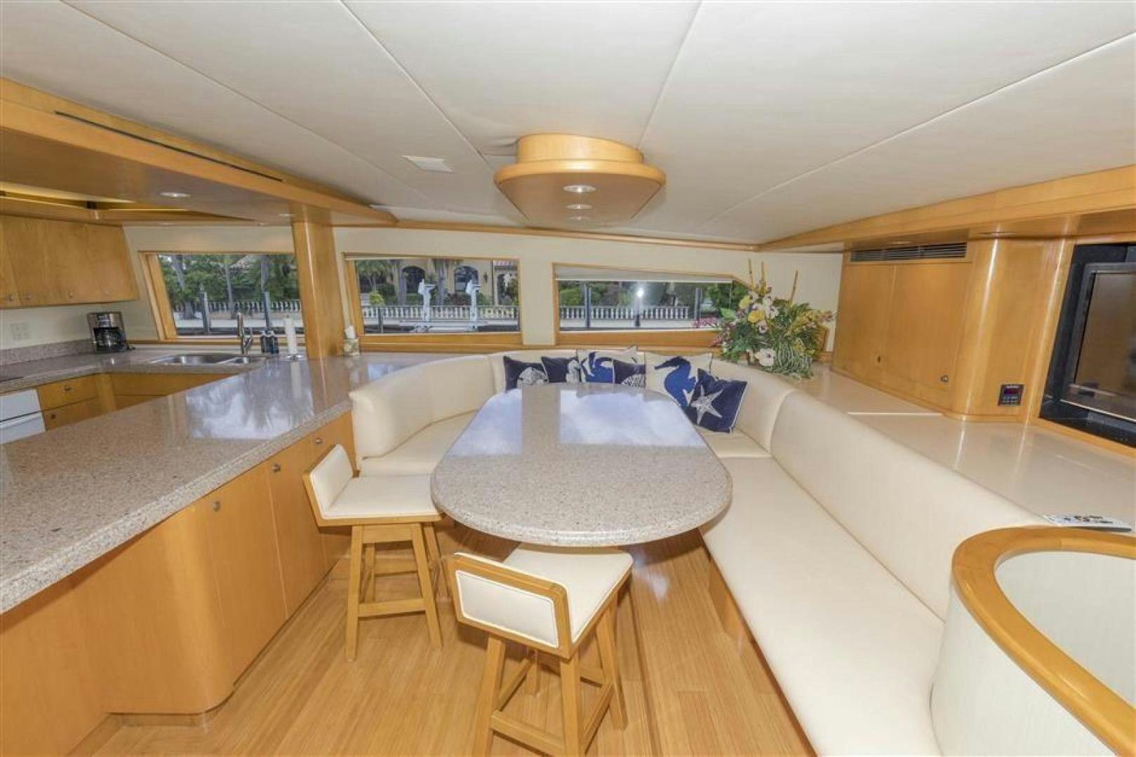 a modern looking kitchen with a dining table and chairs aboard DETERMINATION Yacht for Sale