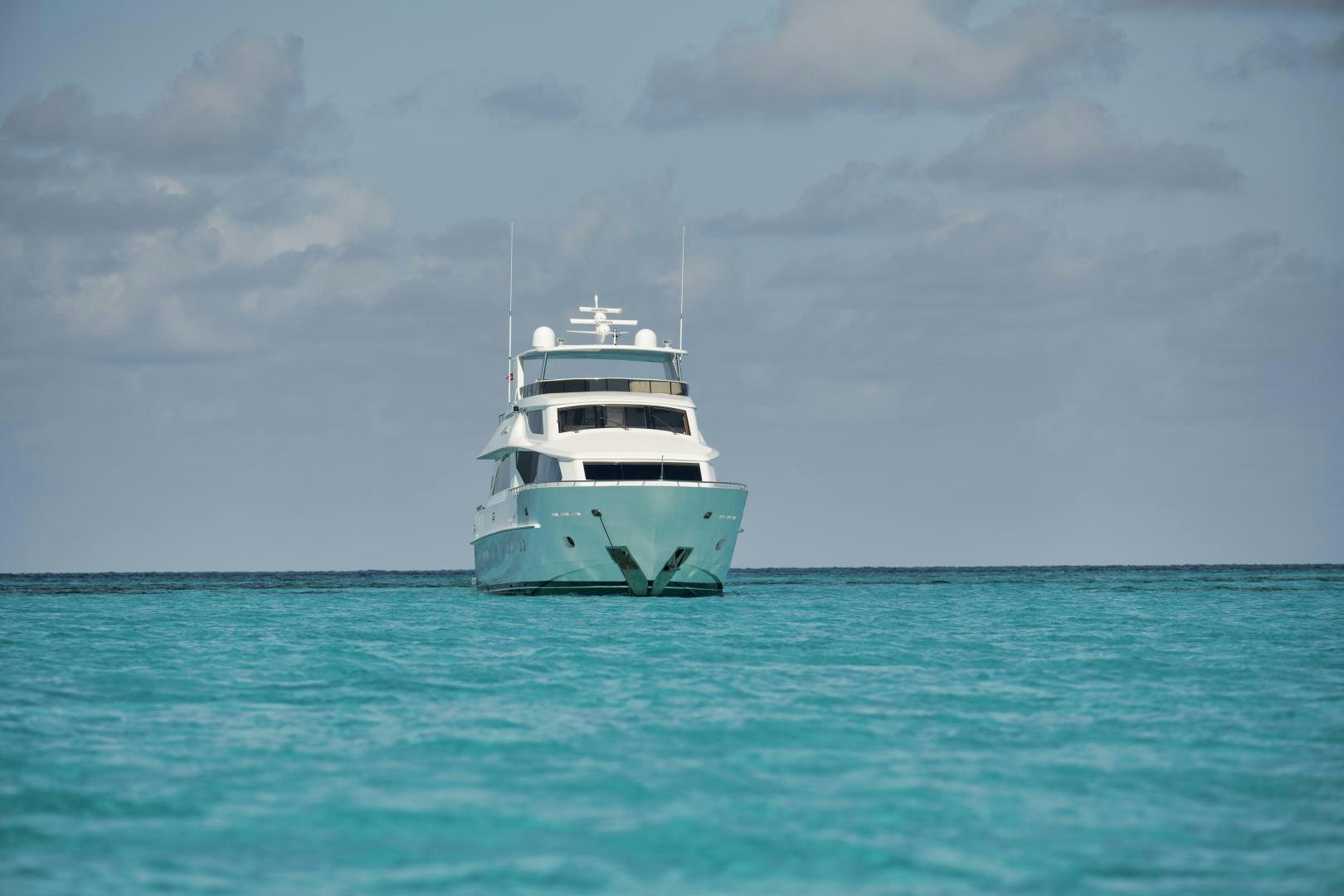 a small white boat in the water aboard LIMITLESS Yacht for Sale