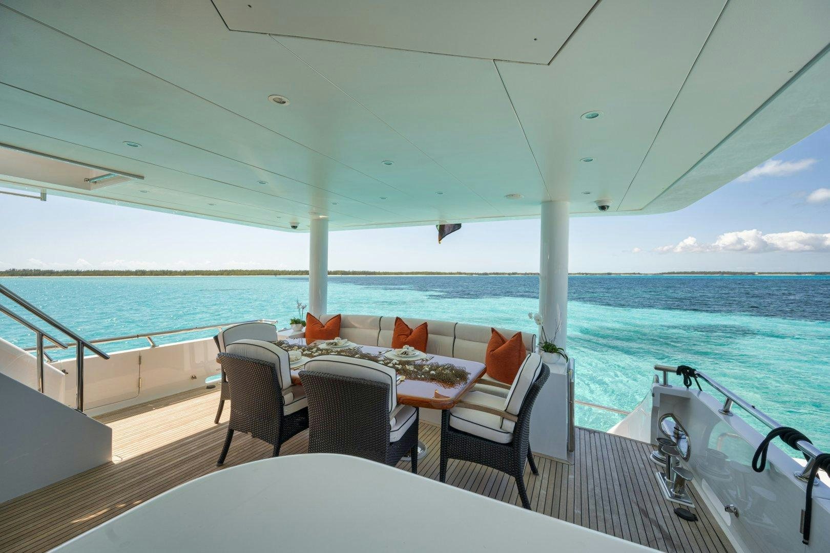 a deck with chairs and tables on it aboard LIMITLESS Yacht for Sale