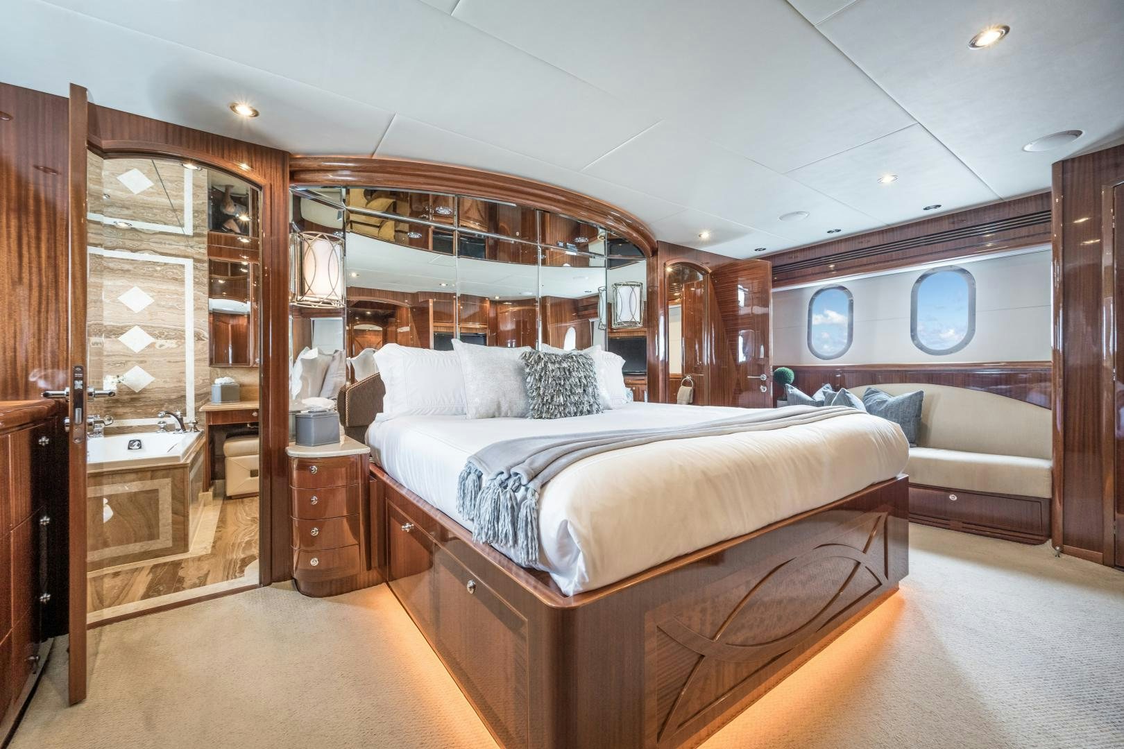 a bedroom with a bed and a mirror aboard LIMITLESS Yacht for Sale