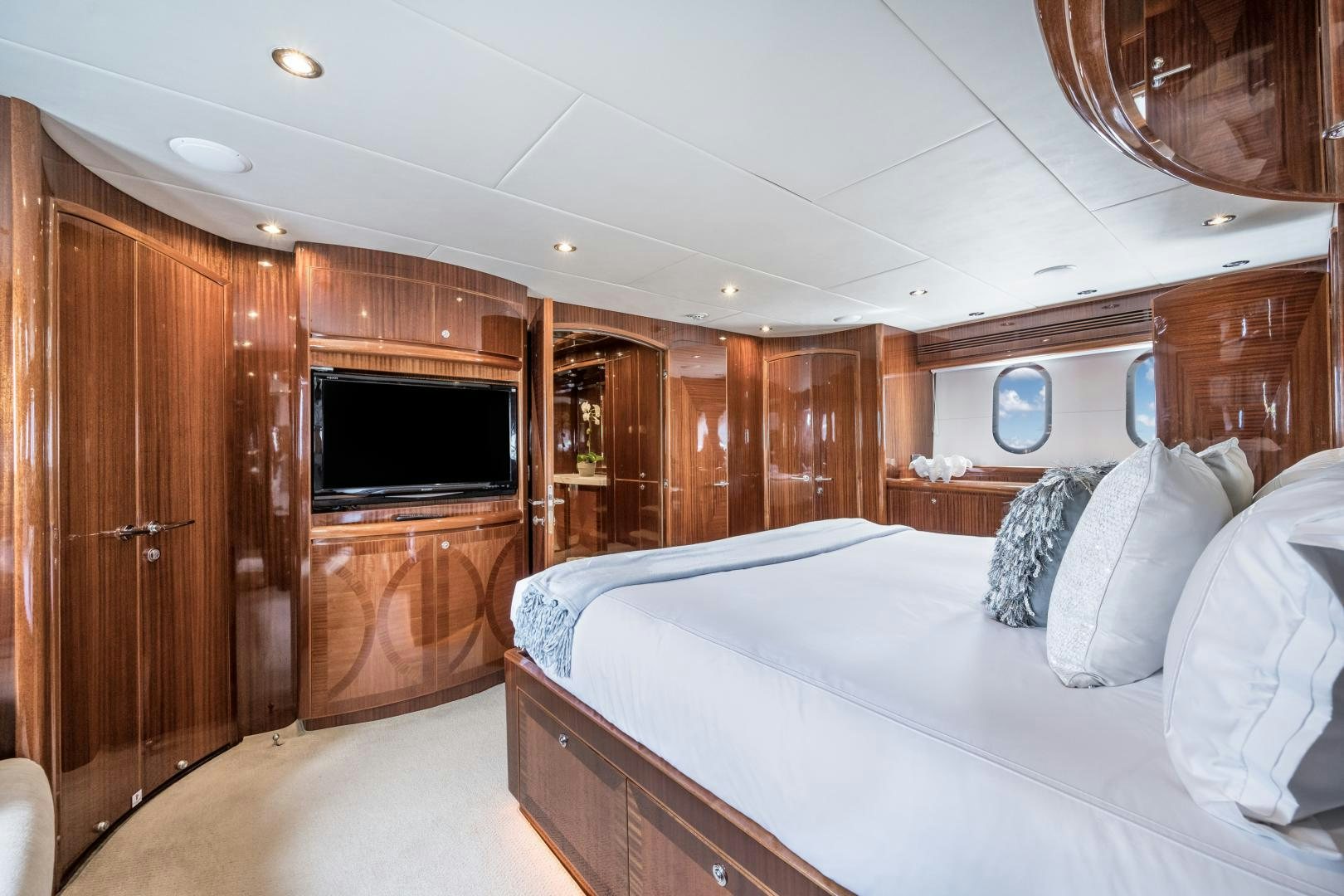 a bedroom with a bed and a television aboard LIMITLESS Yacht for Sale