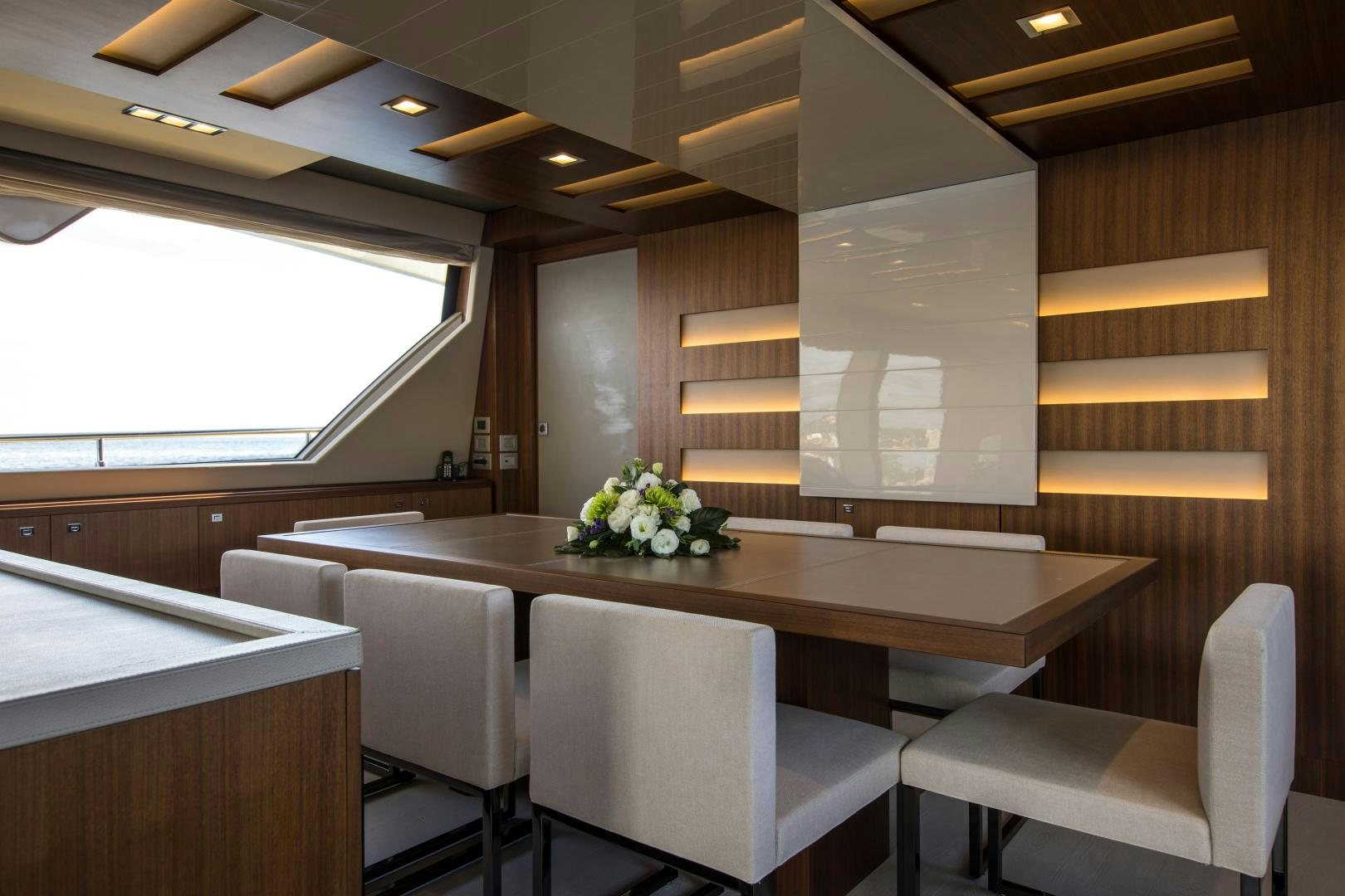 a room with a table chairs and a window aboard CAMPO VERDE Yacht for Sale