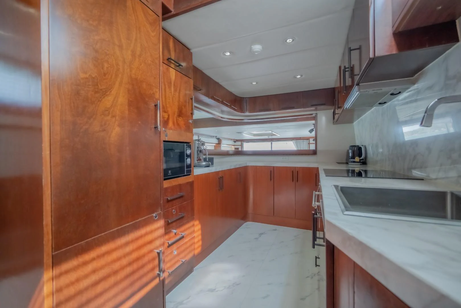 a kitchen with wooden cabinets aboard MIA KAI Yacht for Sale
