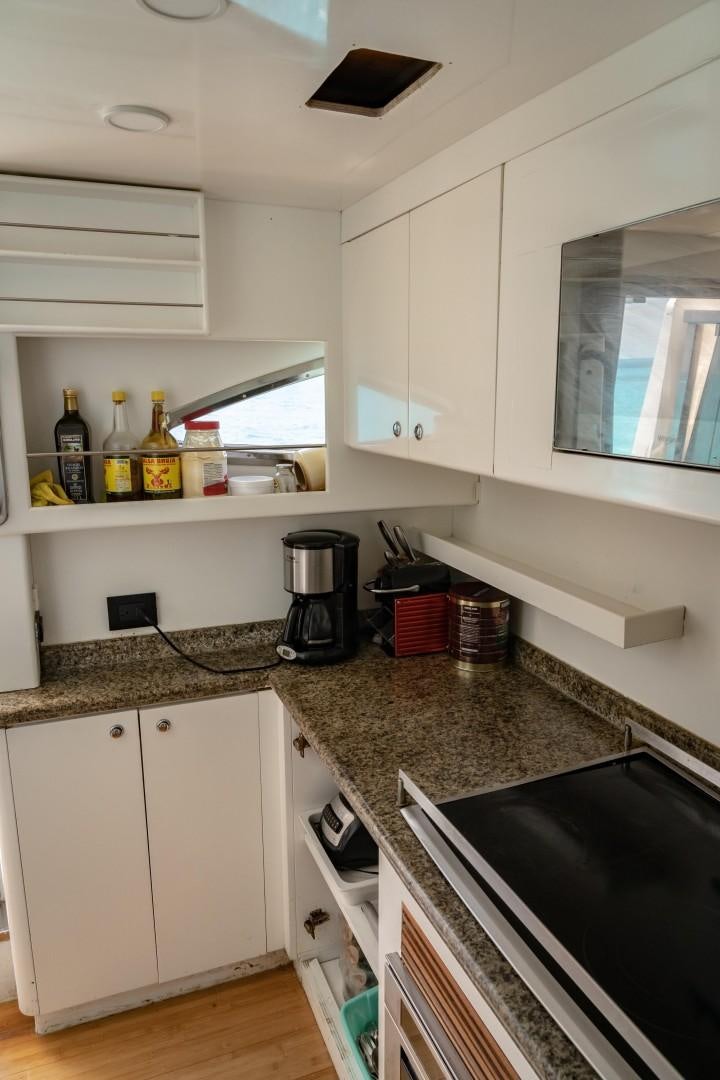 a kitchen with white cabinets aboard EL CAPRICHO Yacht for Sale