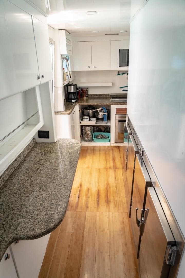 a kitchen with white cabinets aboard EL CAPRICHO Yacht for Sale