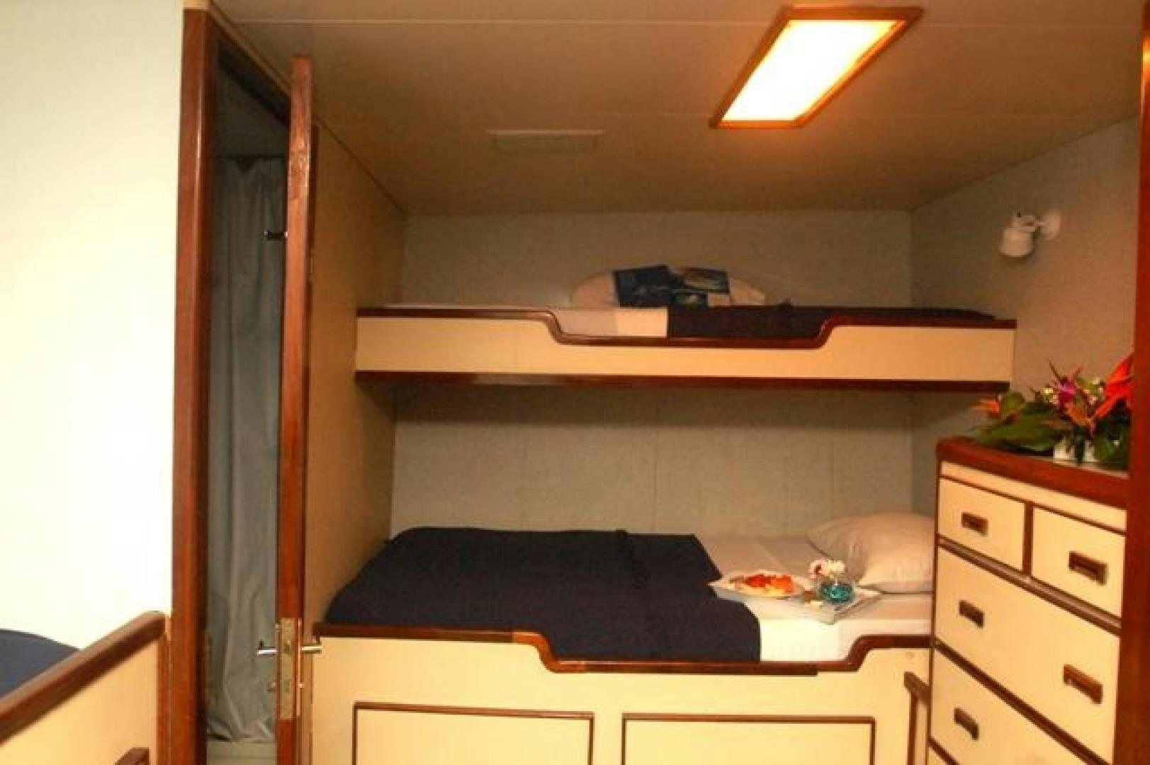 a bedroom with a bed and desk aboard No Name Yacht for Sale