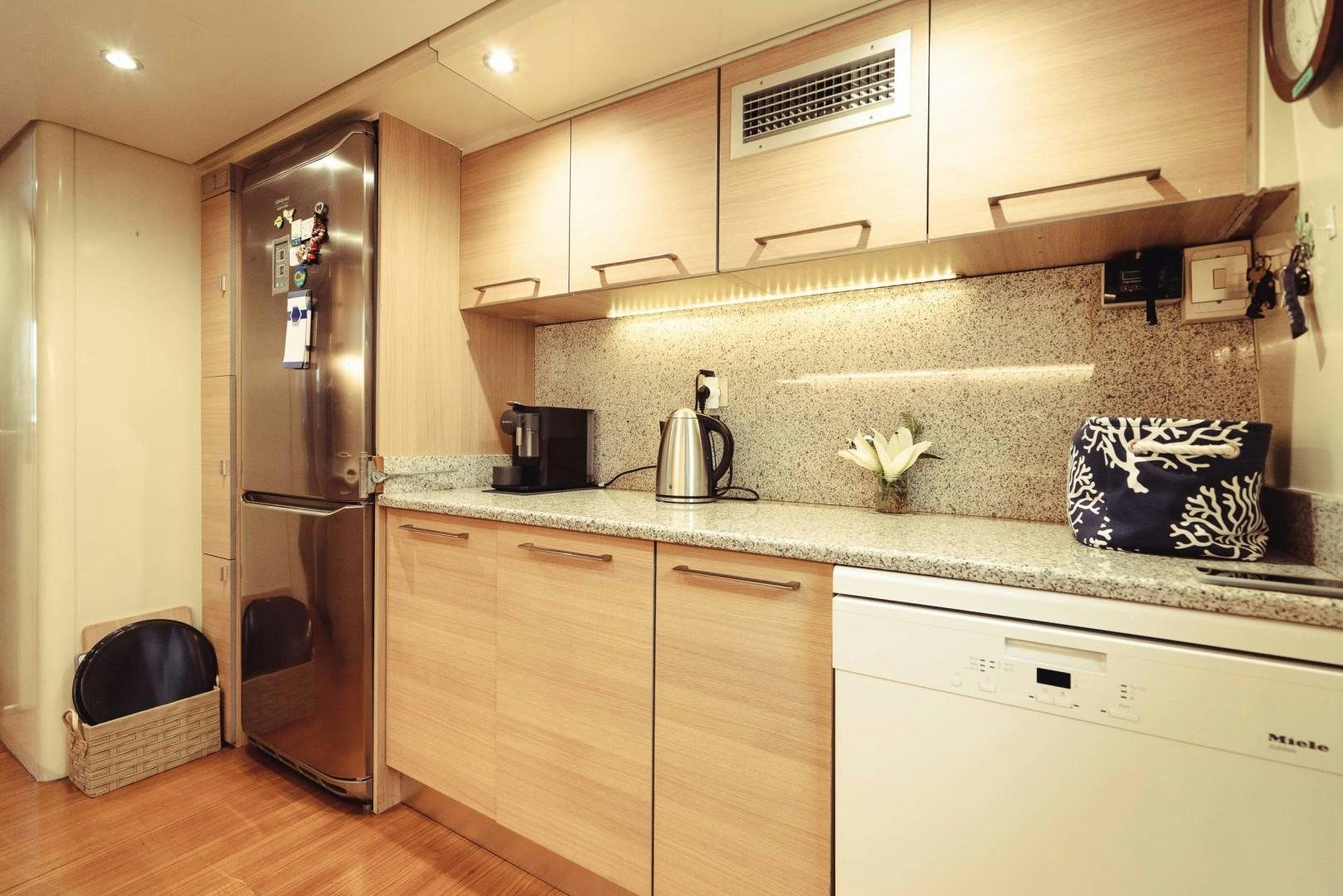 a kitchen with a stainless steel refrigerator aboard WIZARD Yacht for Sale