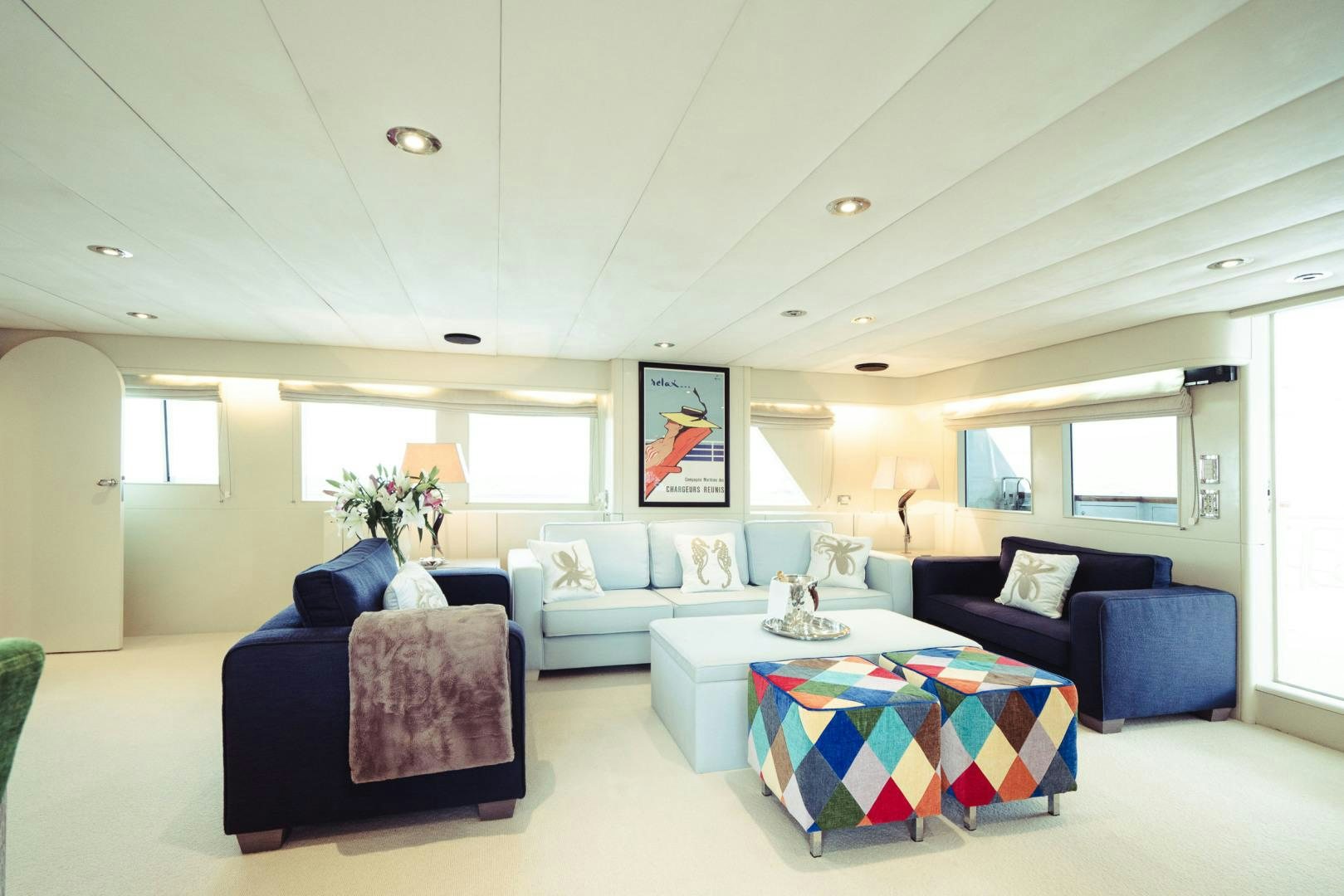 a living room with blue couches aboard WIZARD Yacht for Sale