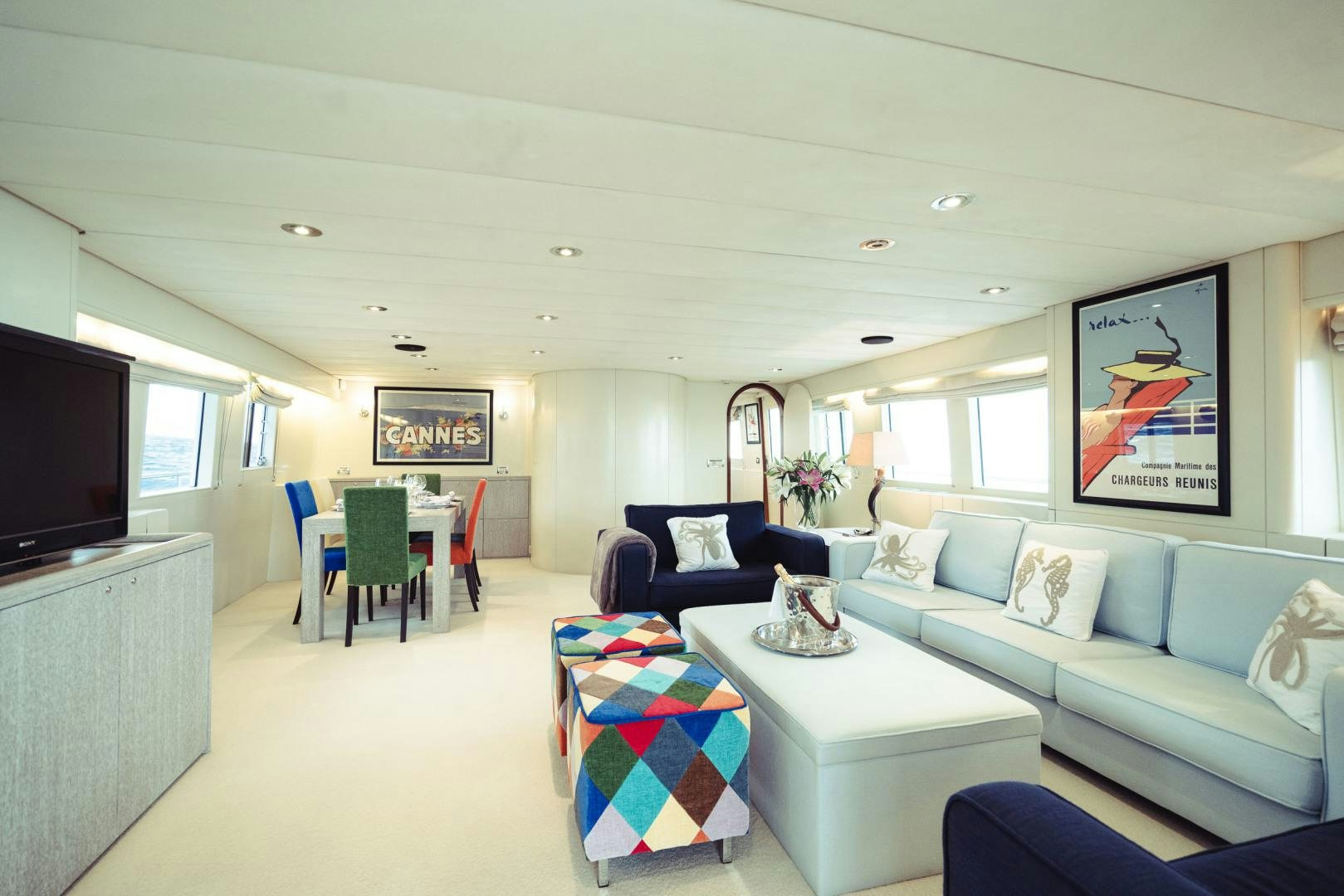 a living room with a blue couch and a television aboard WIZARD Yacht for Sale