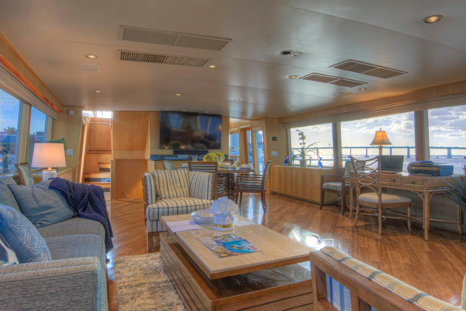 a living room with a large wood floor and a large window aboard LADY LEX Yacht for Sale
