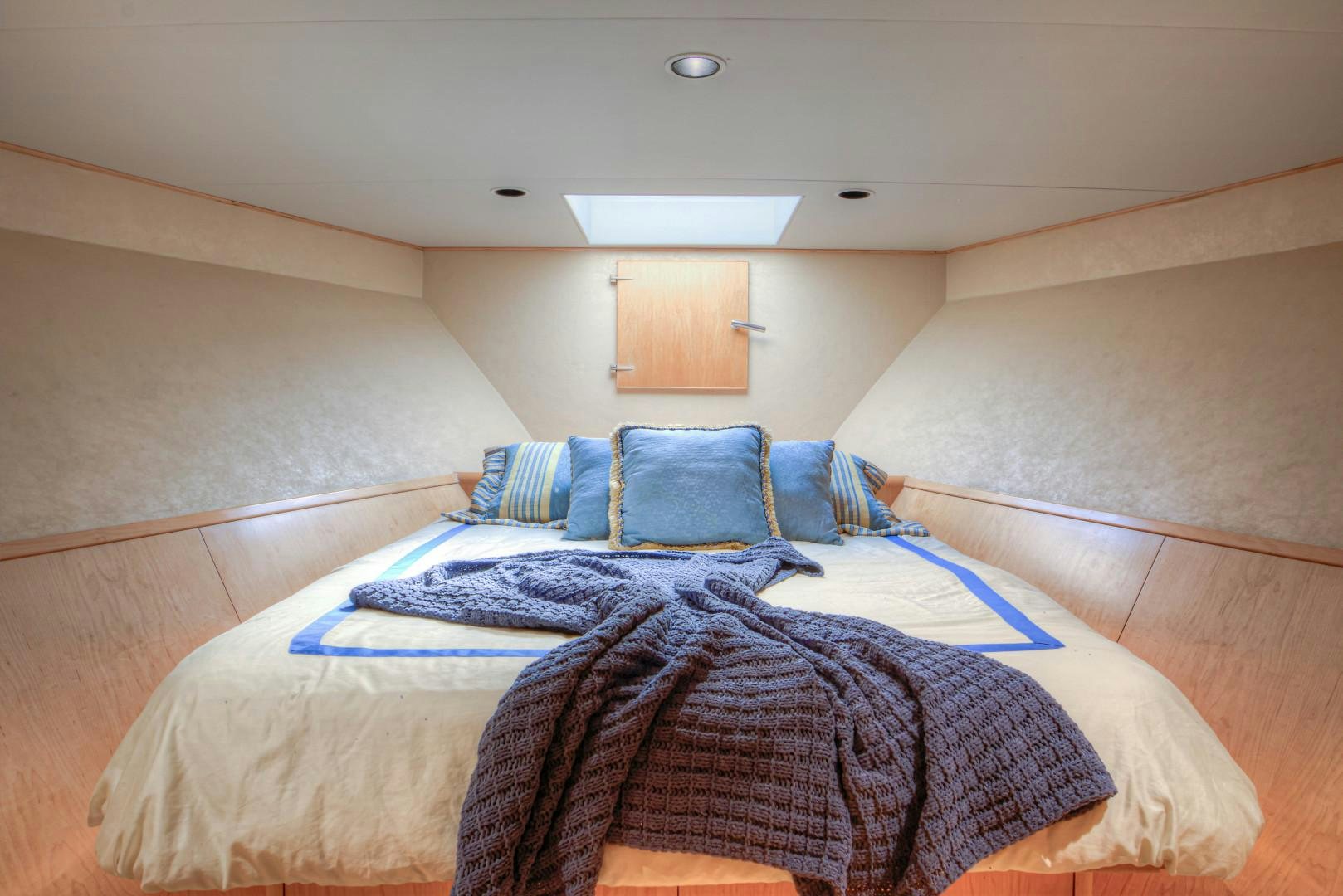 a bed with a blue comforter aboard LADY LEX Yacht for Sale
