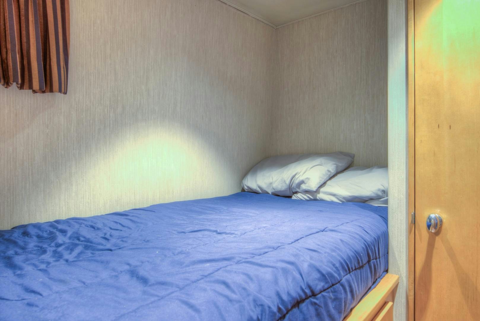 a bed with blue sheets aboard LADY LEX Yacht for Sale