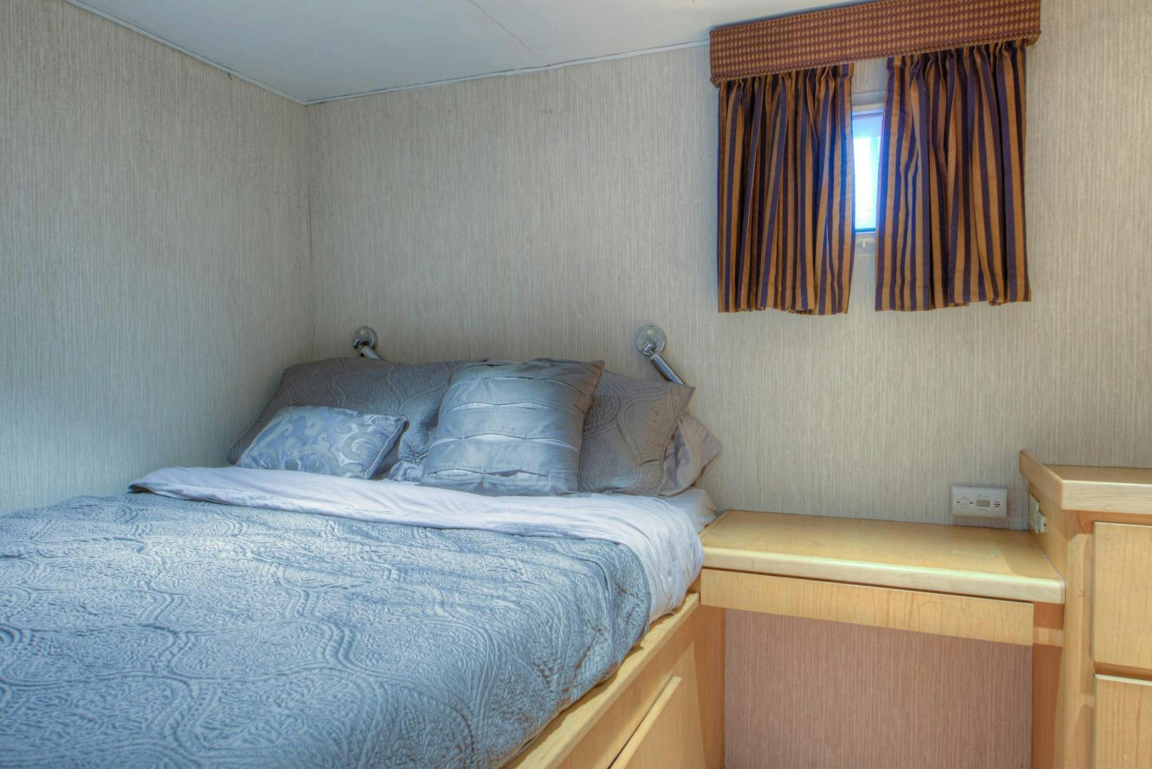 a bed with a blue sheet aboard LADY LEX Yacht for Sale