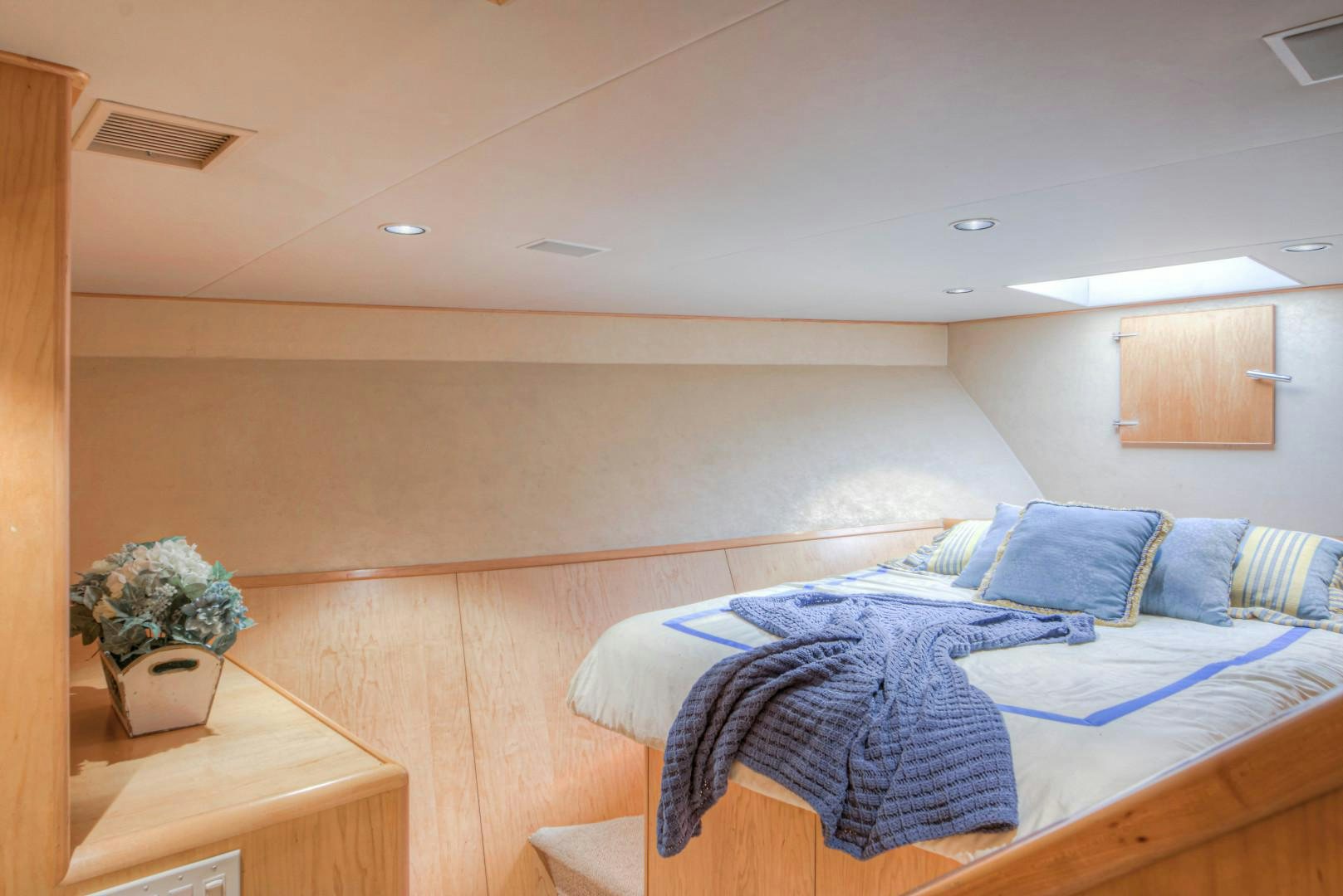 a bedroom with a bed and a plant aboard LADY LEX Yacht for Sale