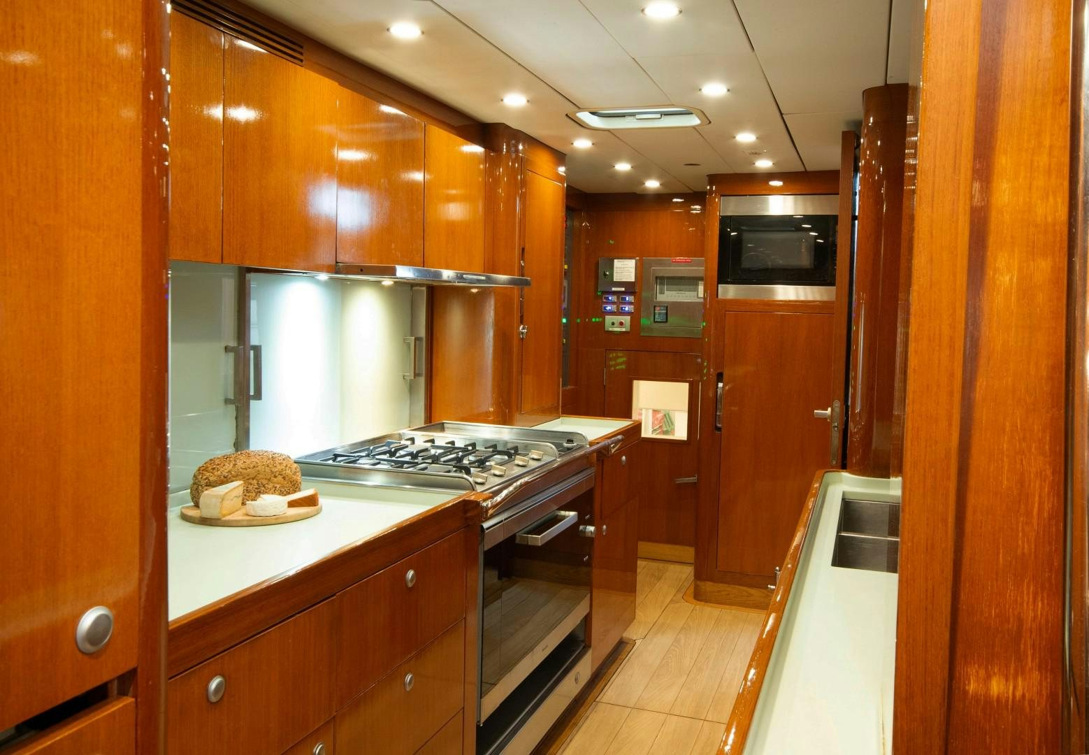 a kitchen with wooden cabinets aboard VARSOVIE Yacht for Sale