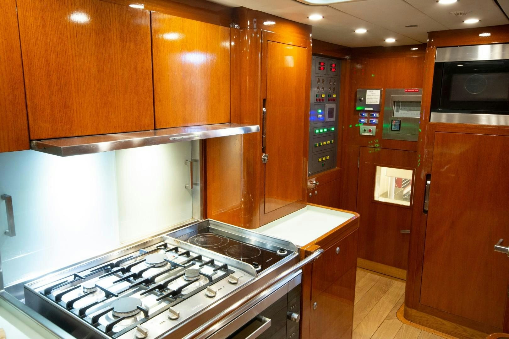 a kitchen with wooden cabinets aboard VARSOVIE Yacht for Sale
