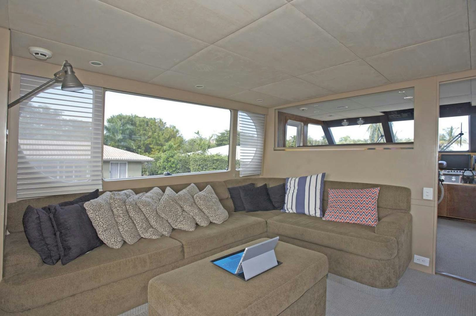 a couch with a coffee table and a window with a view of the trees aboard BRAVO Yacht for Sale