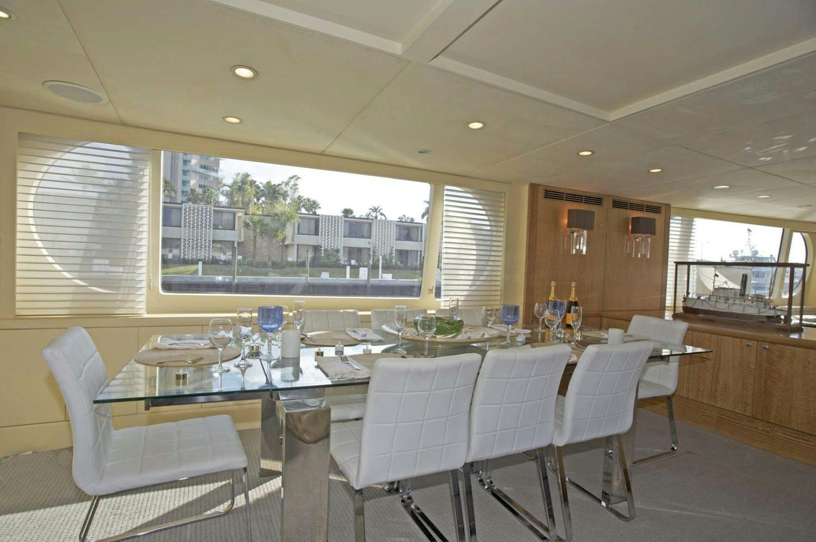 a large dining room with white chairs aboard BRAVO Yacht for Sale