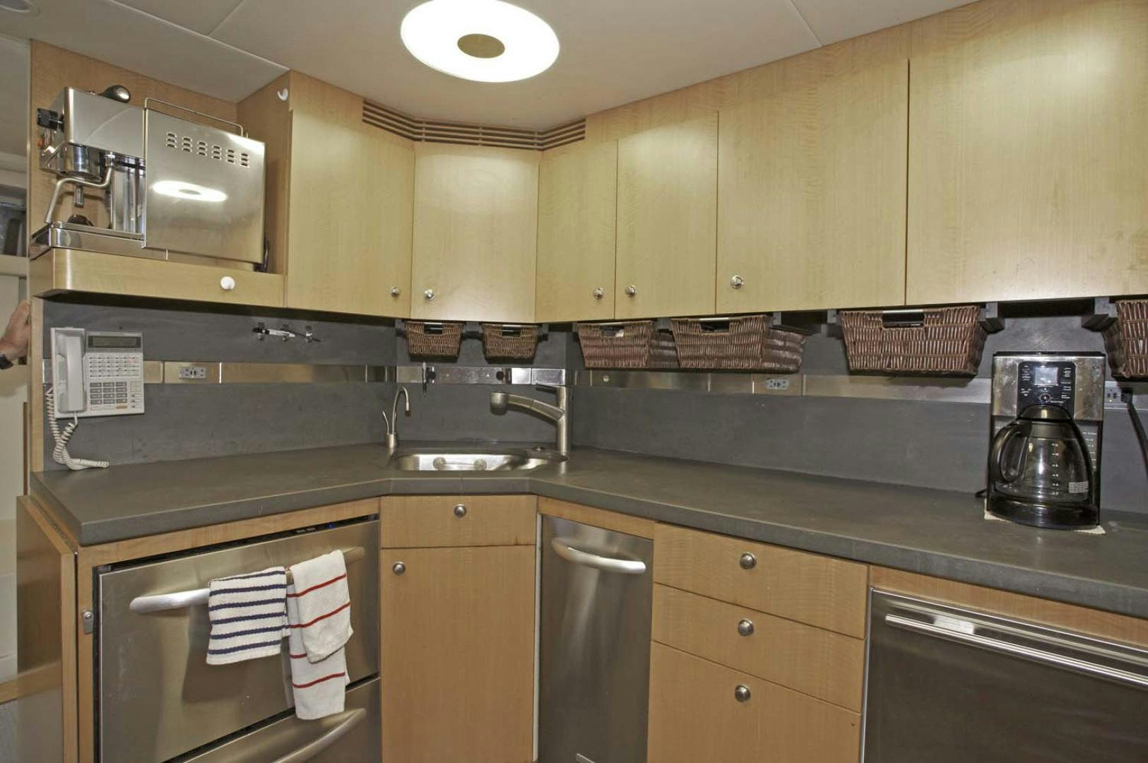 a kitchen with wooden cabinets aboard BRAVO Yacht for Sale