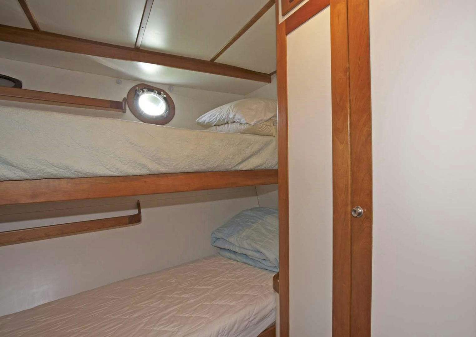 a bed with a light on the wall aboard BRAVO Yacht for Sale