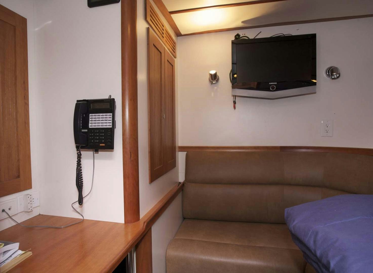 a living room with a television and a couch aboard BRAVO Yacht for Sale