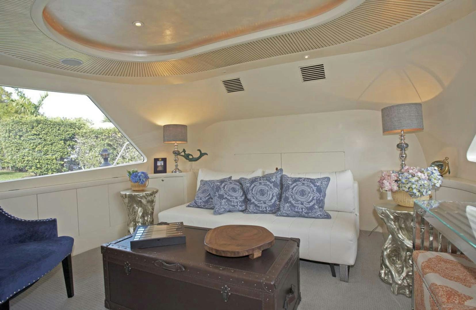 a living room with a large white couch and a large window aboard BRAVO Yacht for Sale