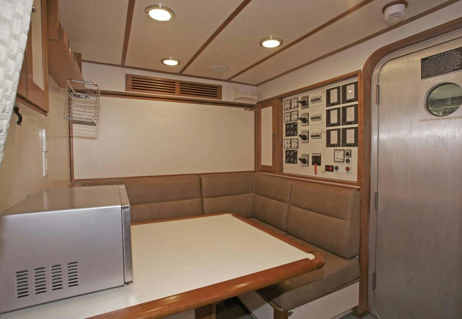 a room with a table and cabinets aboard BRAVO Yacht for Sale