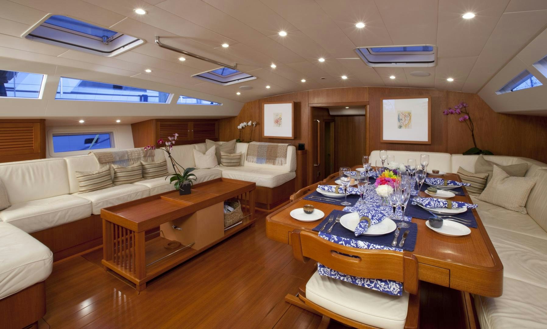 a living room with a table and couches aboard VIRAGO Yacht for Sale
