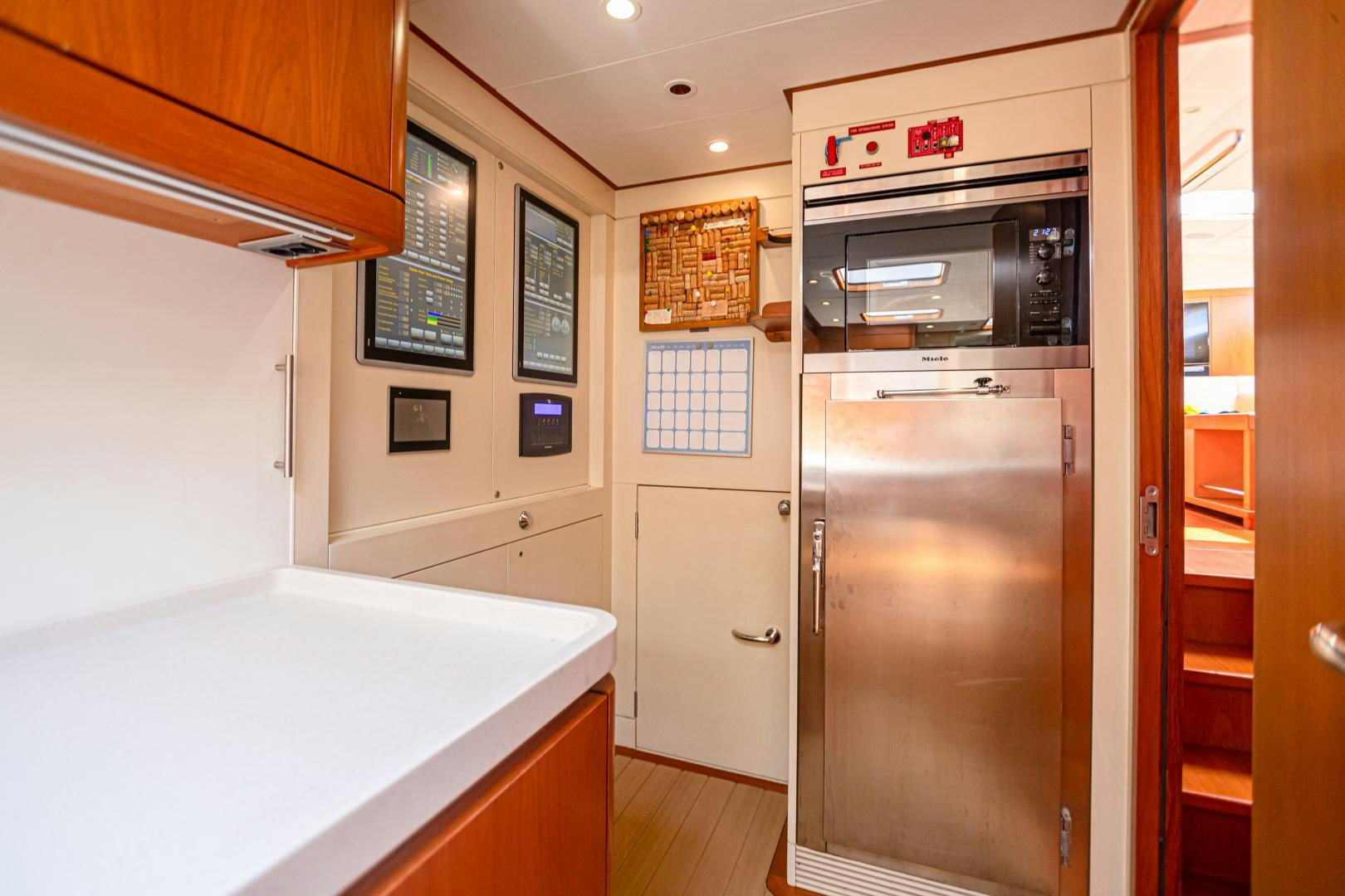 a kitchen with a refrigerator and microwave aboard VIRAGO Yacht for Sale