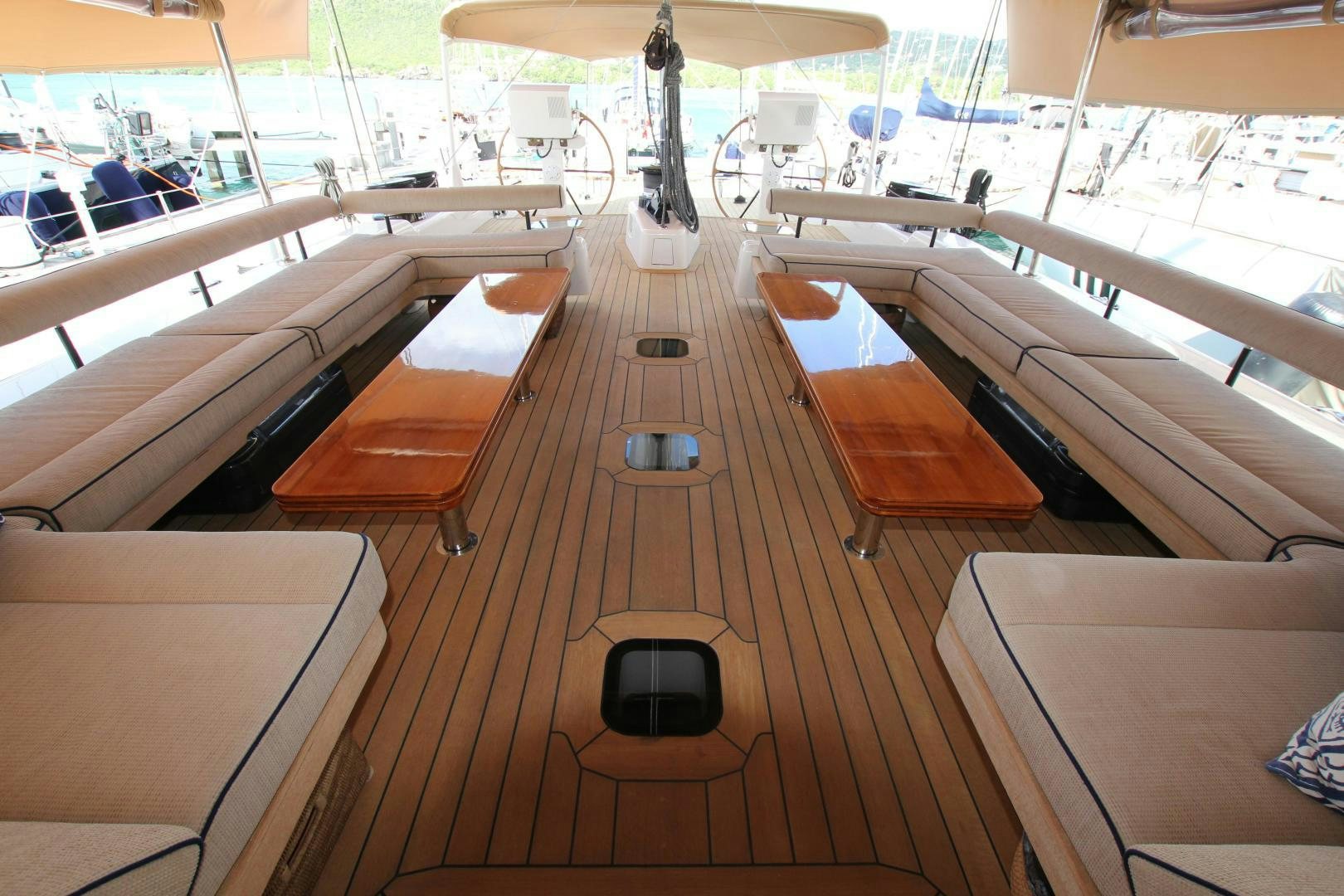 a wooden deck with a black chair and a black seat aboard VIRAGO Yacht for Sale