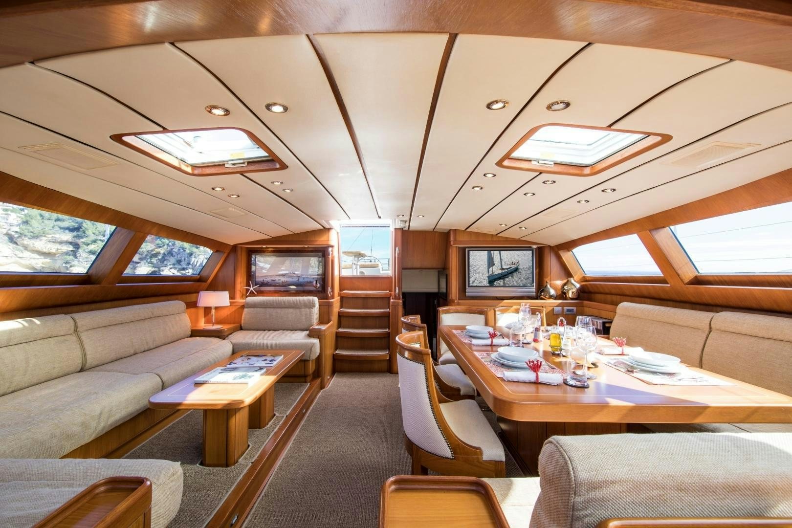 a living room with a table and couches aboard MEDUSA Yacht for Sale