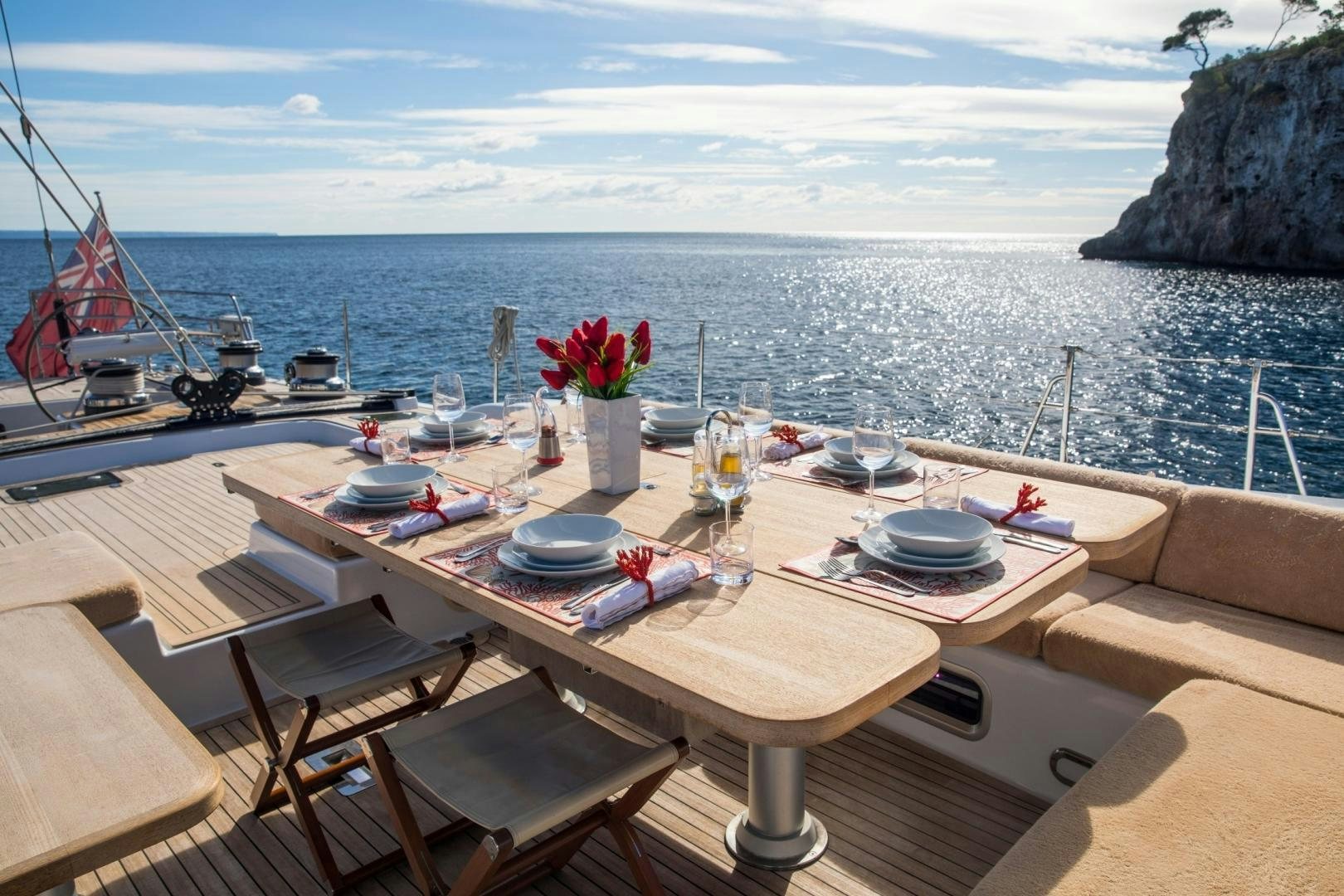 a table with plates and flowers on it by the water aboard MEDUSA Yacht for Sale