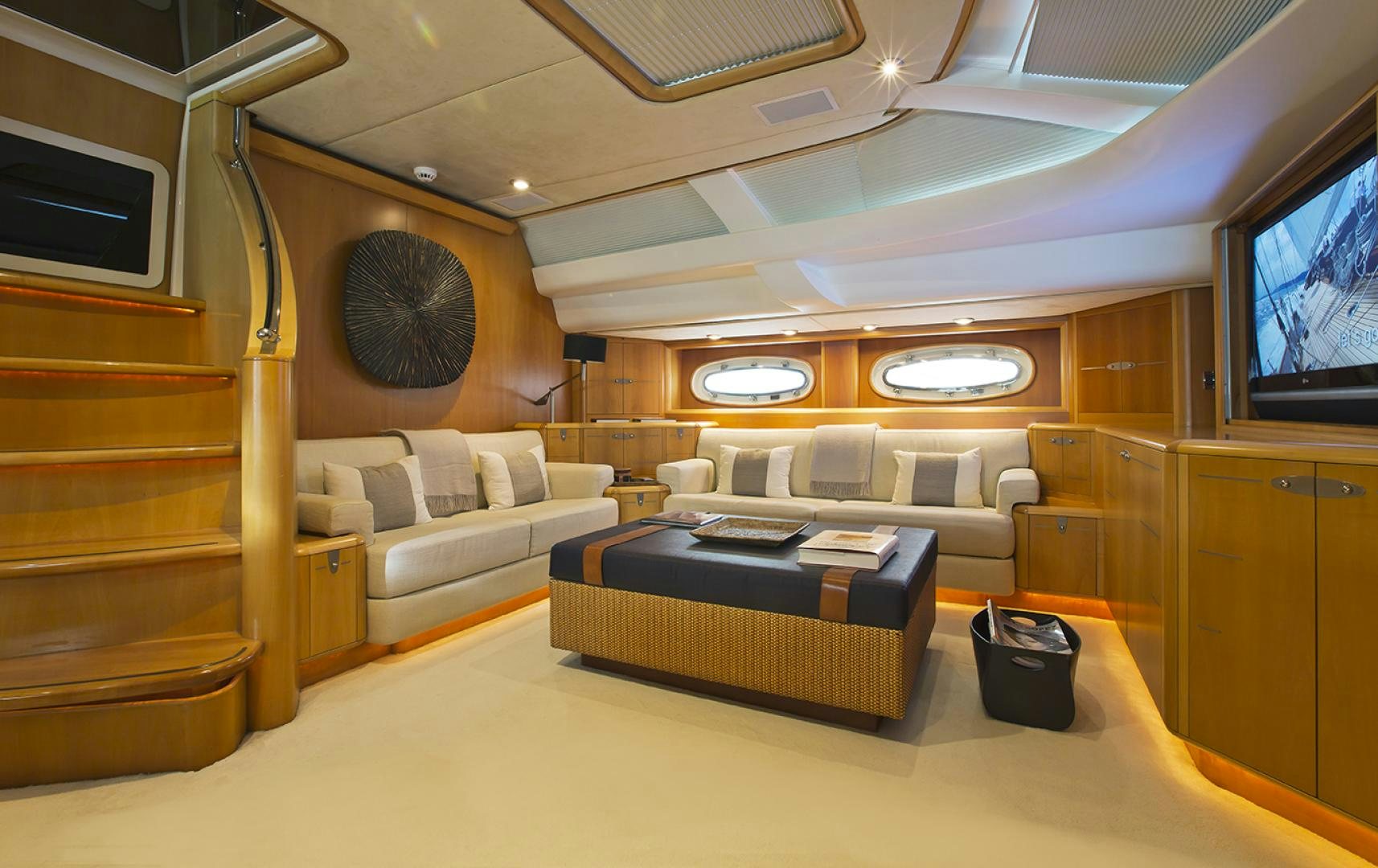 a living room with a large round mirror aboard HAVANA OF LONDON Yacht for Sale