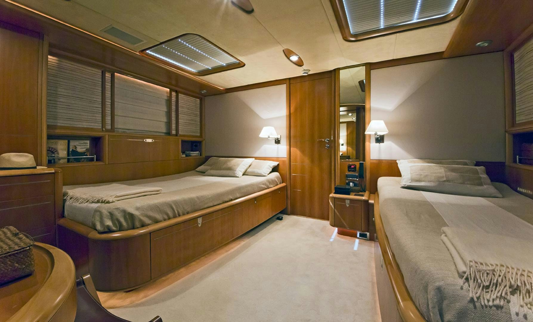 a room with beds and a desk aboard HAVANA OF LONDON Yacht for Sale