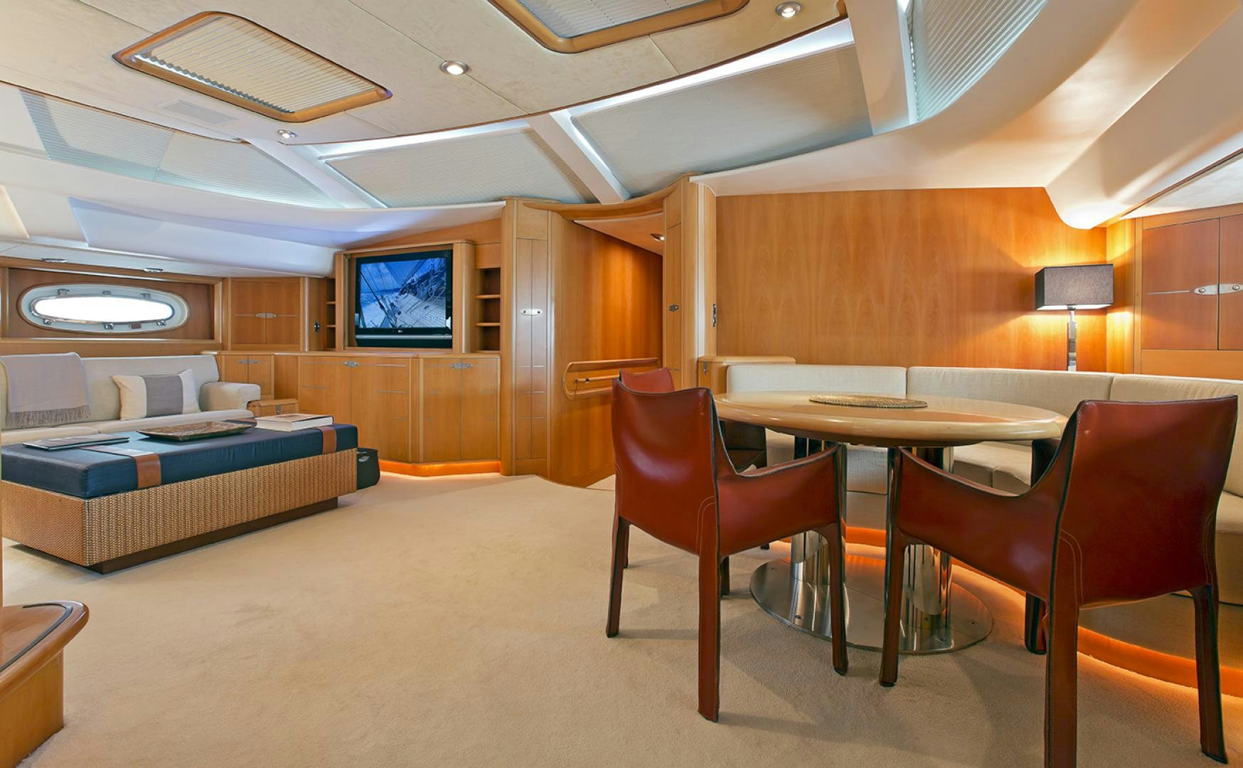 a room with a bed and a table and chairs aboard HAVANA OF LONDON Yacht for Sale