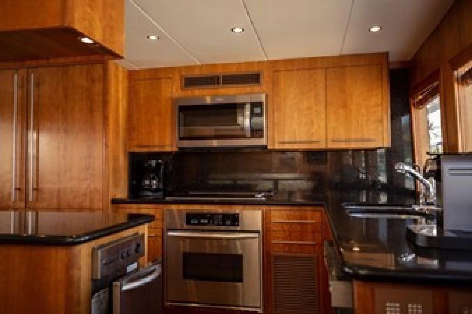a kitchen with wooden cabinets aboard TAIMA Yacht for Sale