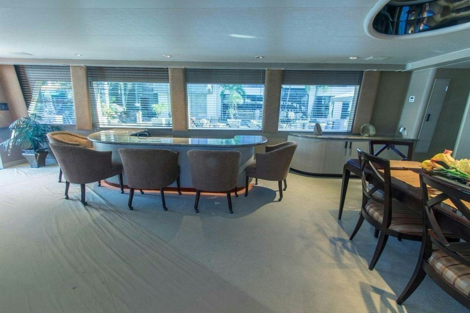 a large room with a table and chairs and a large window aboard MONARCH Yacht for Sale