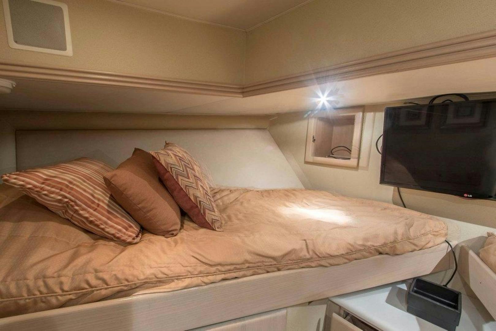 a bed with a television on the wall aboard MONARCH Yacht for Sale