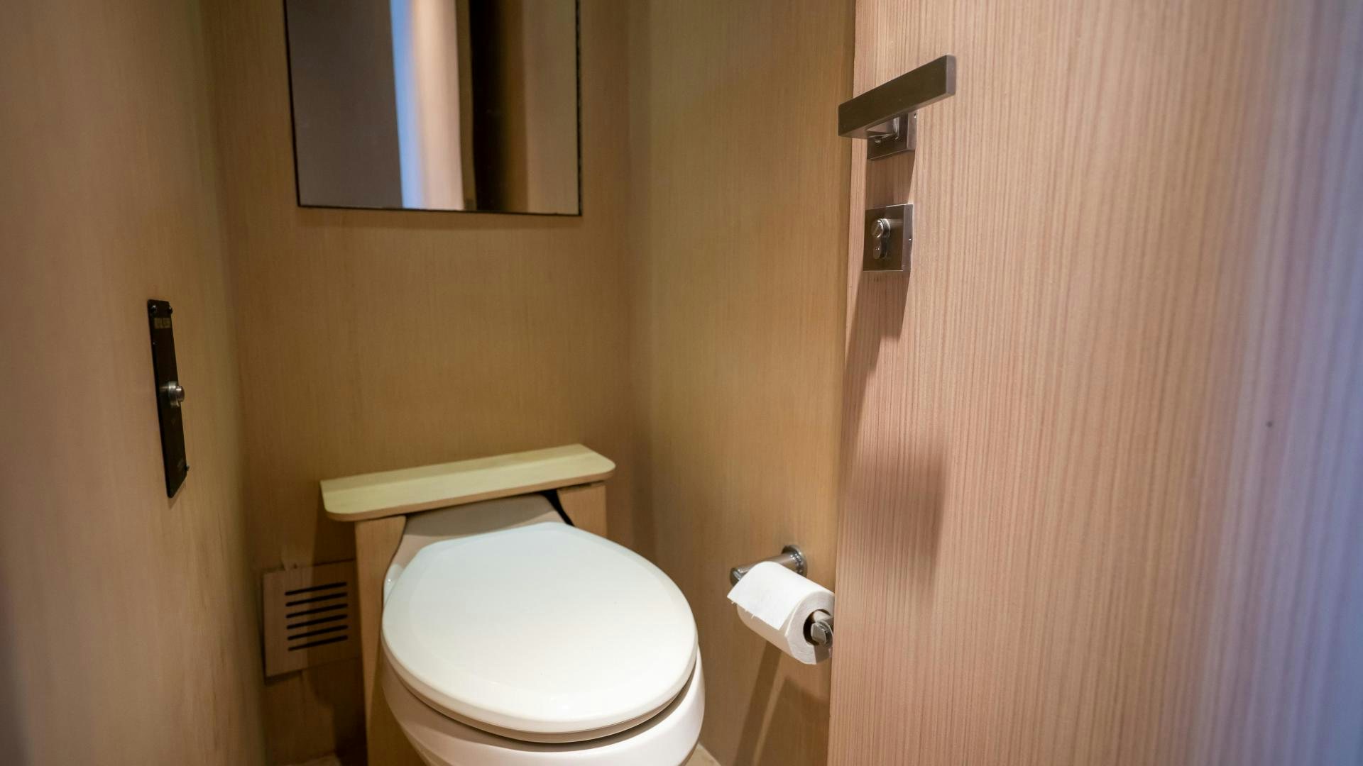 a bathroom with a toilet and a mirror aboard MARAZUL Yacht for Sale