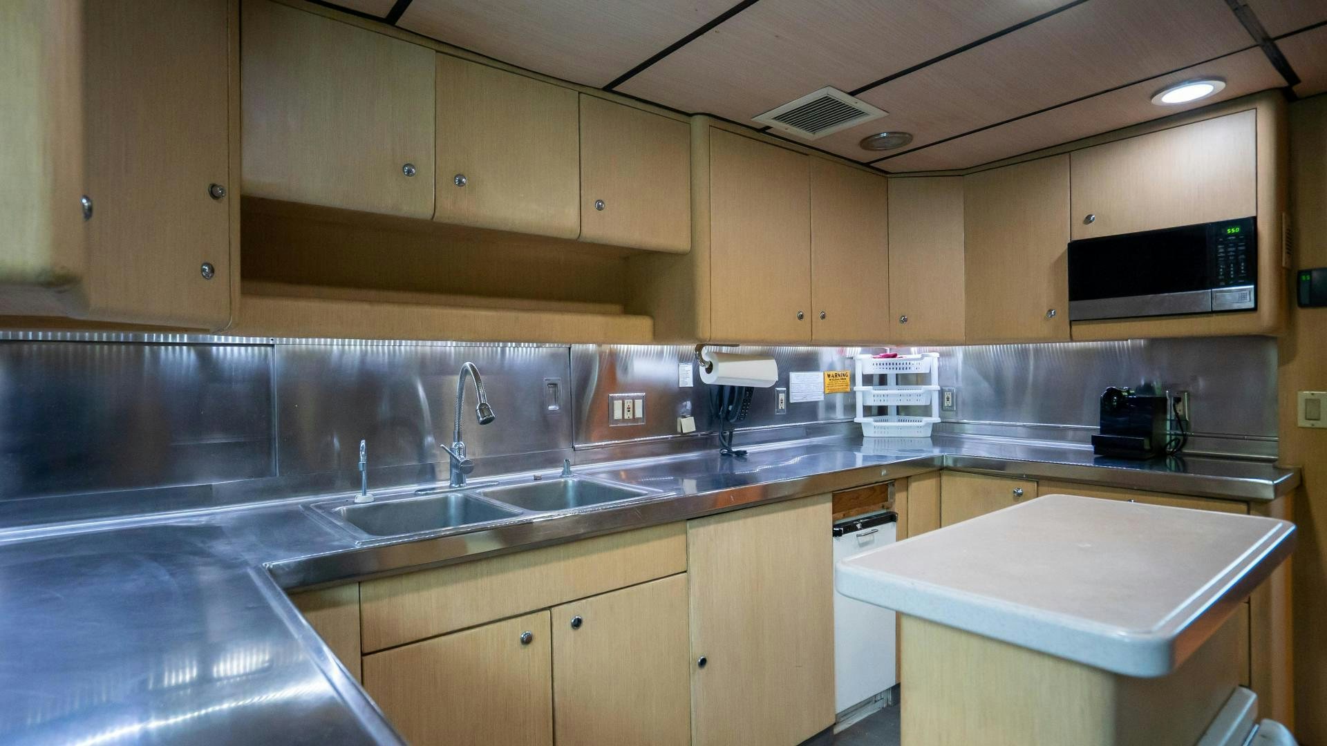 a kitchen with wooden cabinets aboard MARAZUL Yacht for Sale