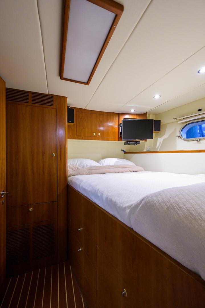 a bed with a television on the wall aboard MY DESTINY Yacht for Sale