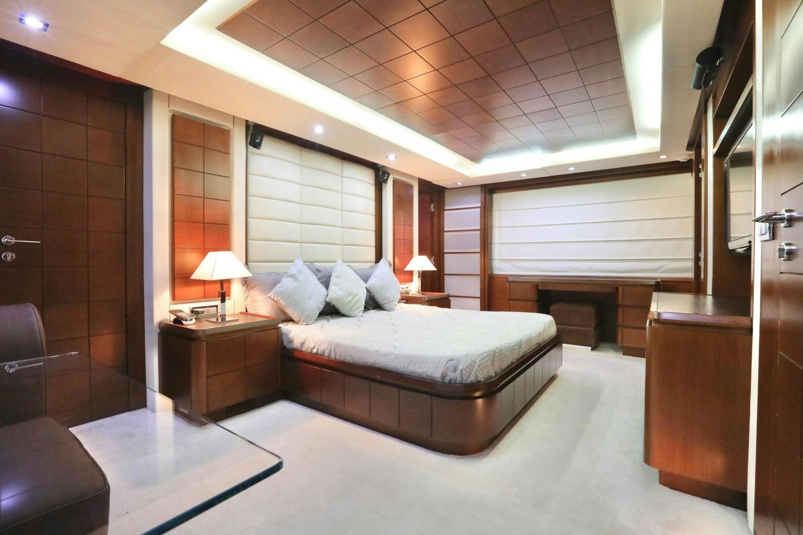 a bedroom with a bed and a desk aboard ANDREIKA Yacht for Sale