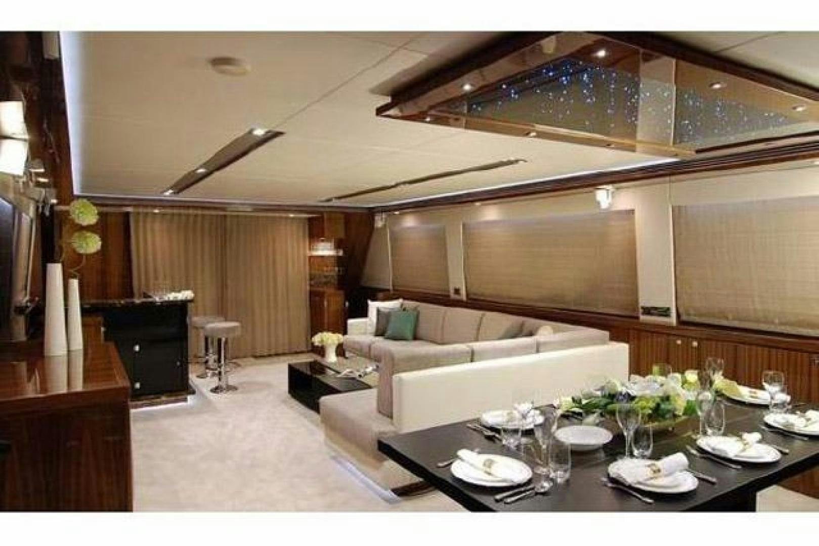 a modern living room with a large table and chairs aboard ENCORE Yacht for Sale